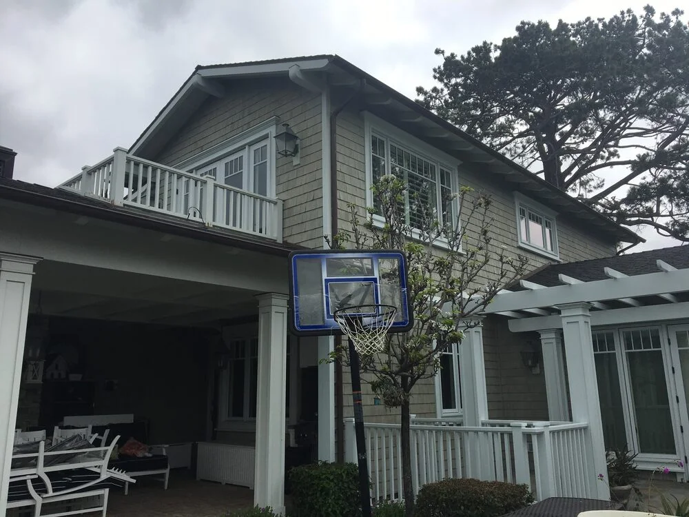 Coastal grey home with white trim and pergola painted by Franklin Custom Finish